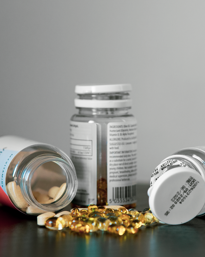 Home Close-up of various pill bottles and vitamins spilled on a table.